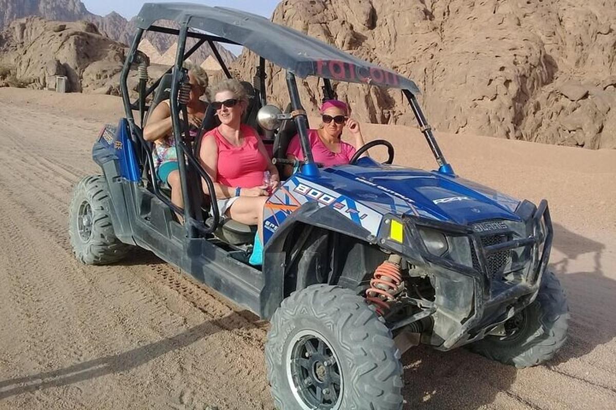 un gruppo di persone che viaggiano su un'auto da cross nel deserto