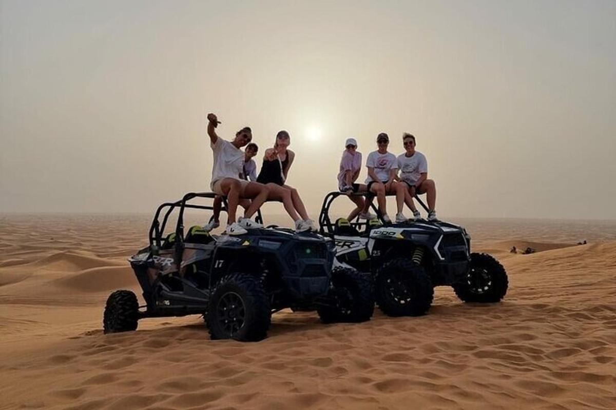 a group of people sitting on top of atvs in the desert