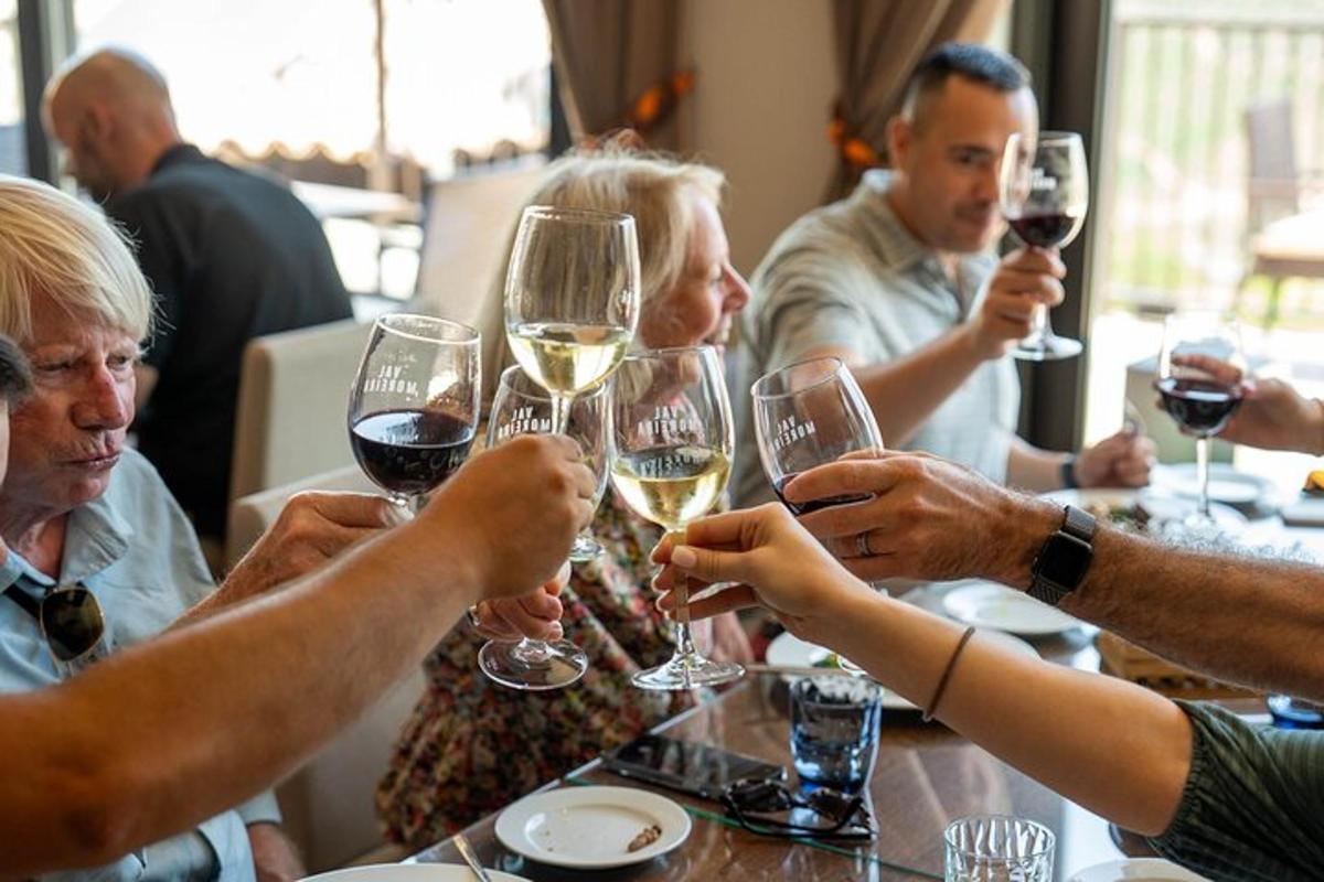 eine Gruppe von Menschen sitzt an einem Tisch und trinkt Wein