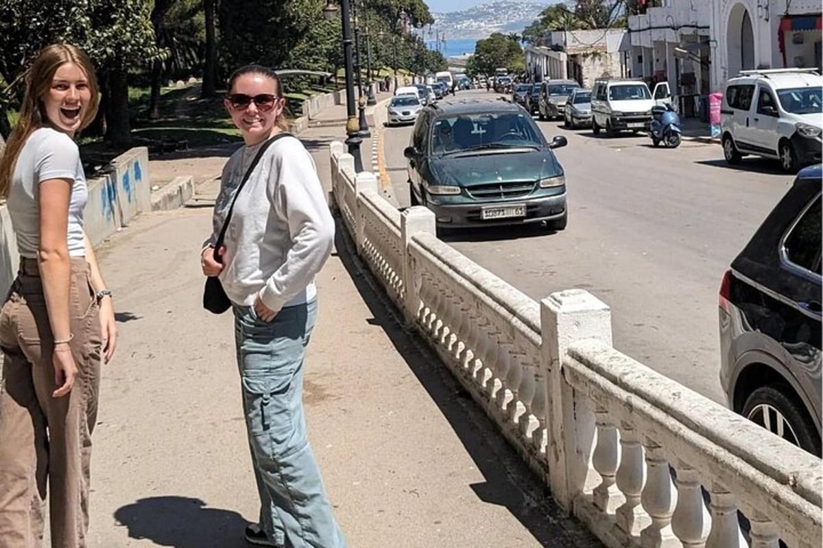 two women standing on a bridge over a street