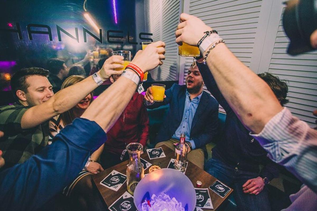 skupina lidí u stolu zvedá sklenice