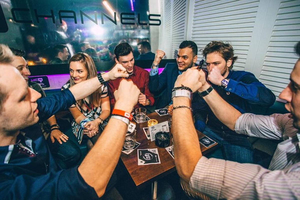 skupina lidí držících se za ruce kolem stolu