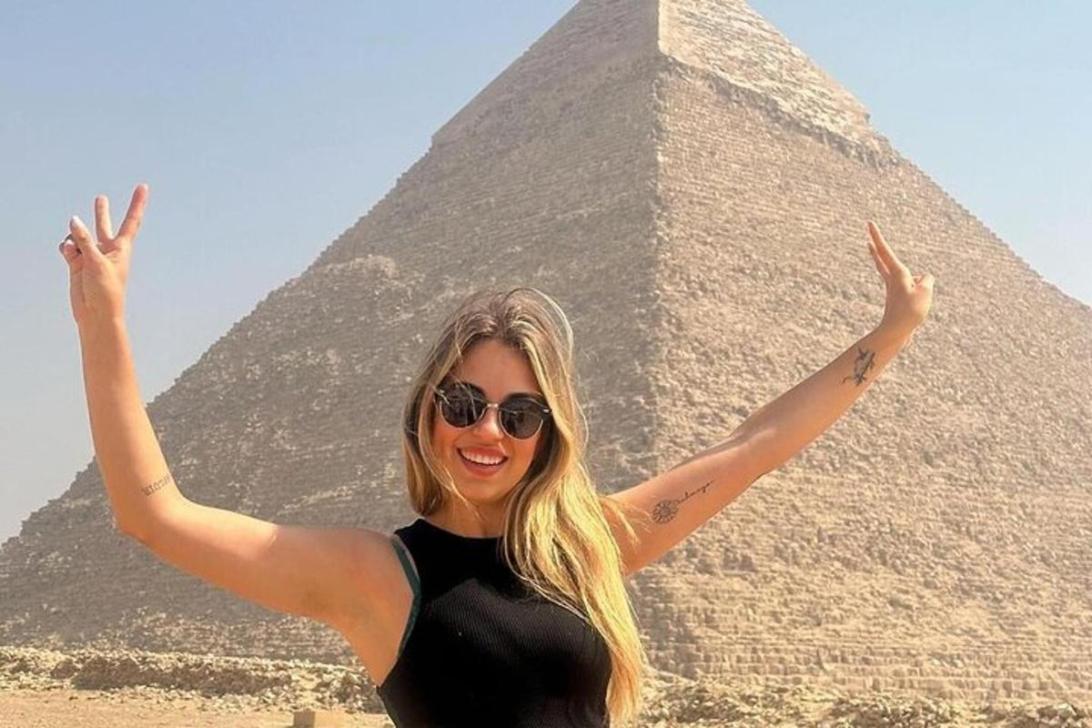 žena se slunečními brýlemi stojící před pyramidou