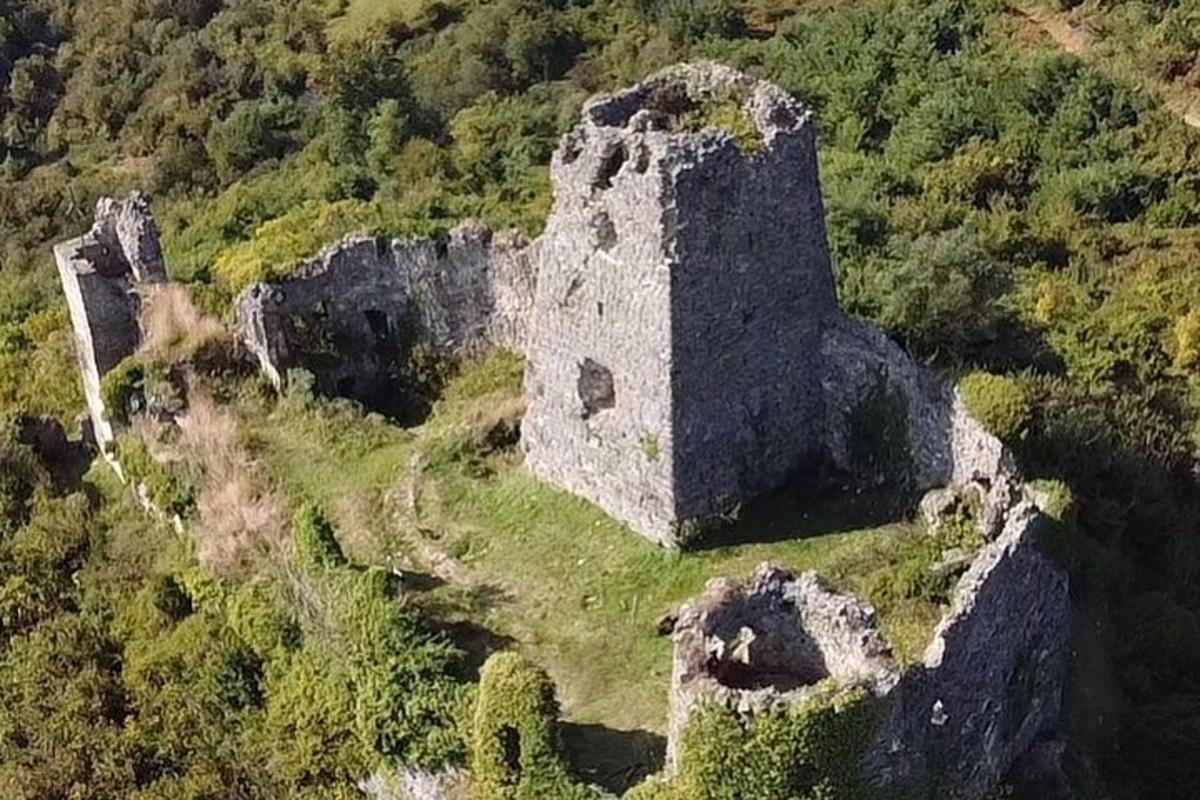 un vecchio edificio in cima a una collina con alberi