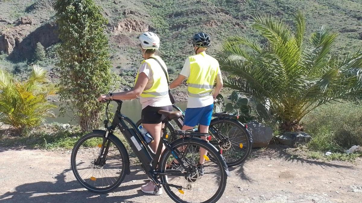 dues persones dempeus en una bicicleta a la muntanya