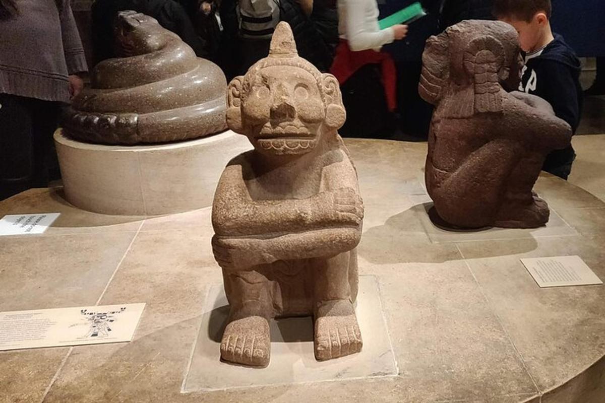 socha osoby na stole s dalšími artefakty
