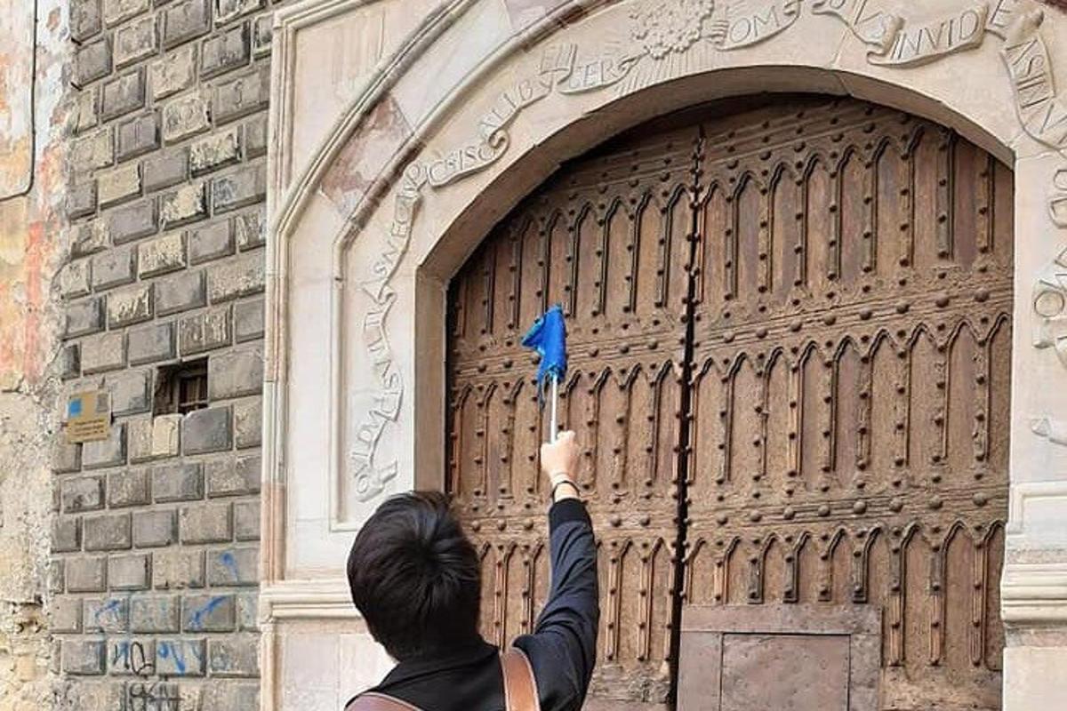 seseorang memegang objek biru di hadapan pintu