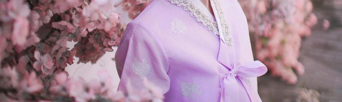 un vestit morat penjat a una paret amb flors