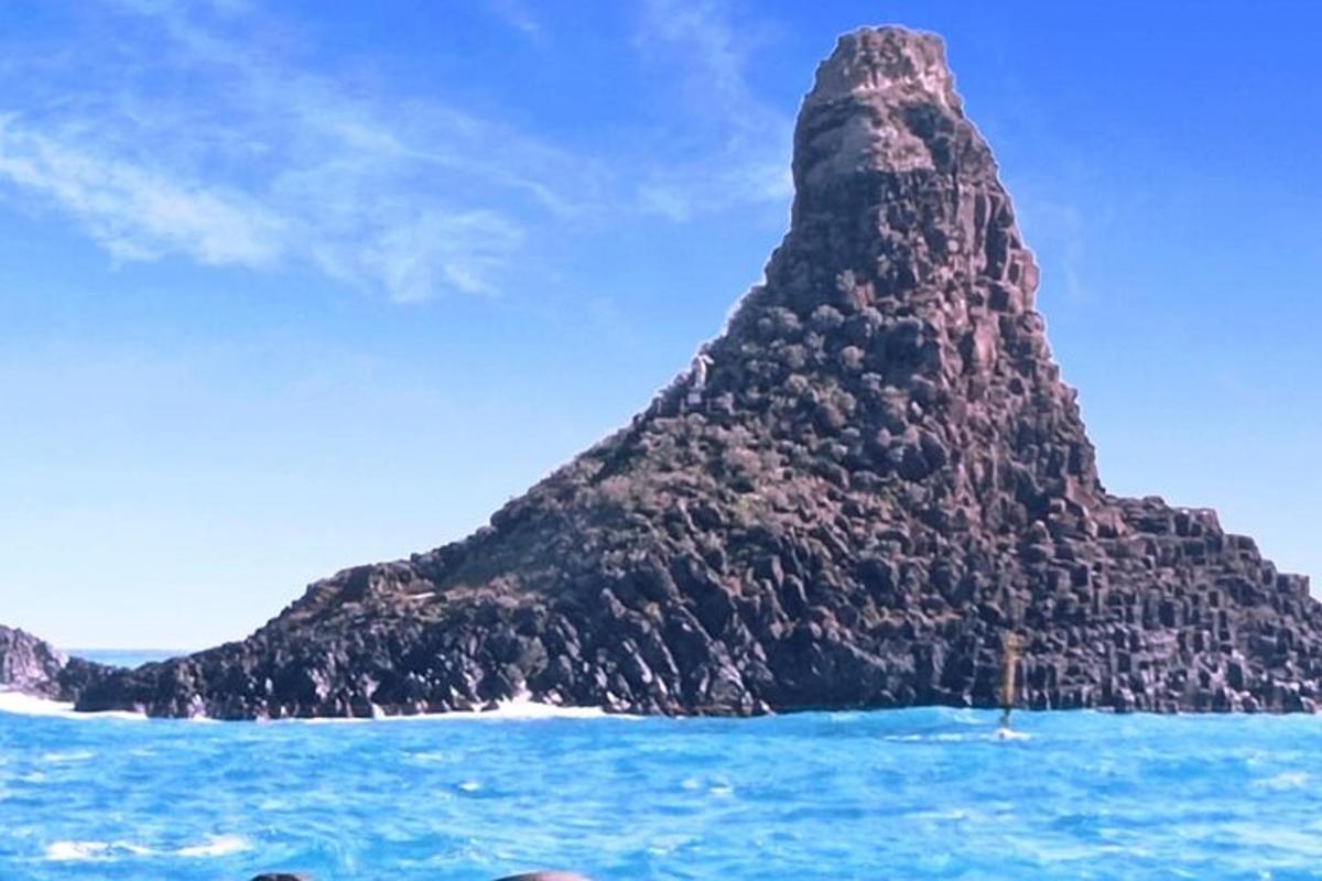 Una isla rocosa en el océano con agua azul.