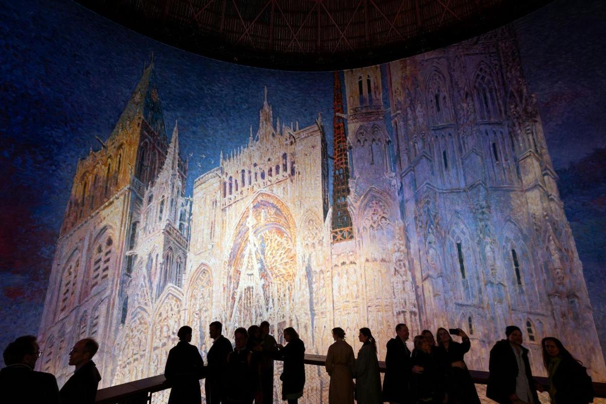 a group of people standing in front of a painting of a cathedral