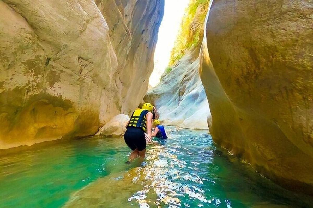 una persona in piedi nell'acqua in un canyon