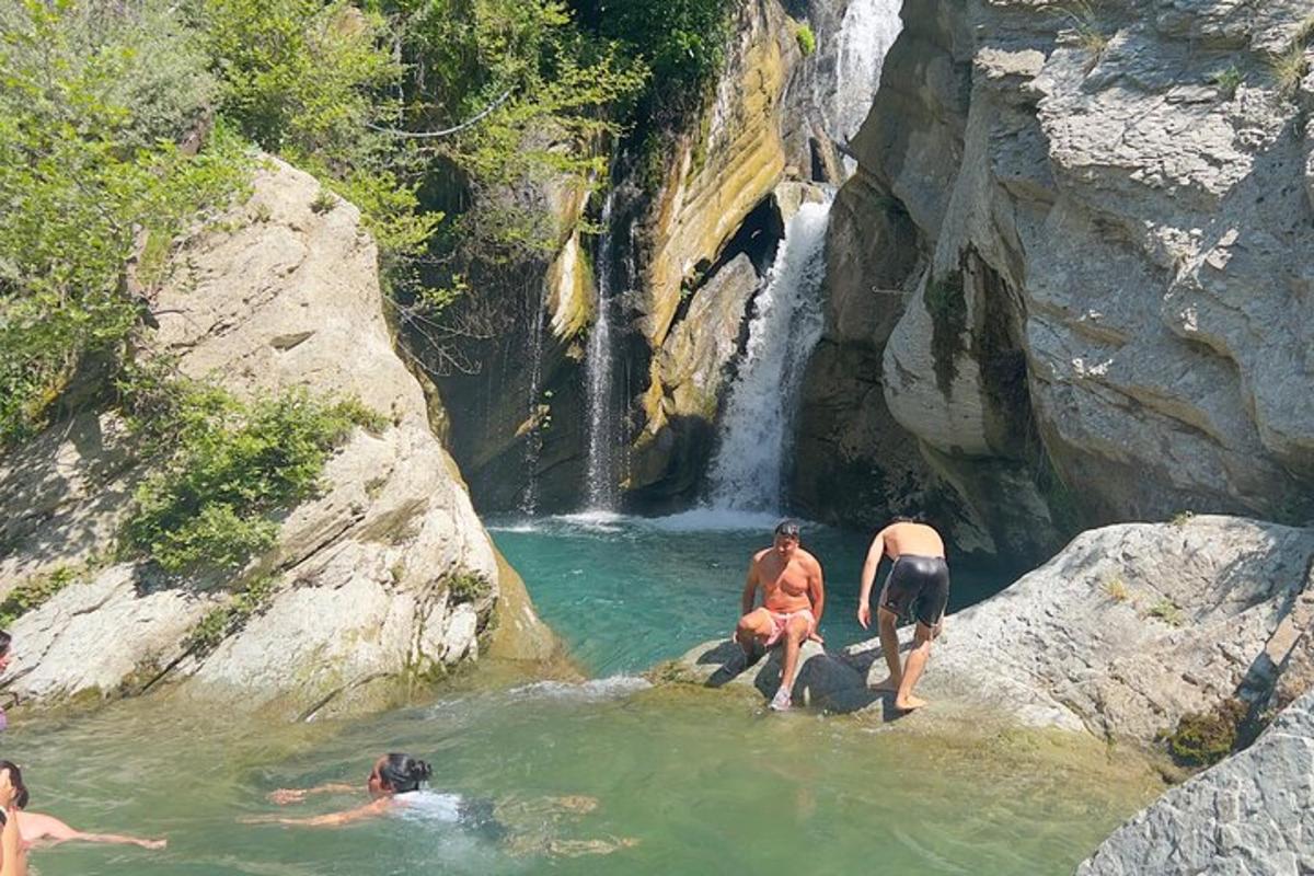 um grupo de pessoas na água perto de uma cachoeira
