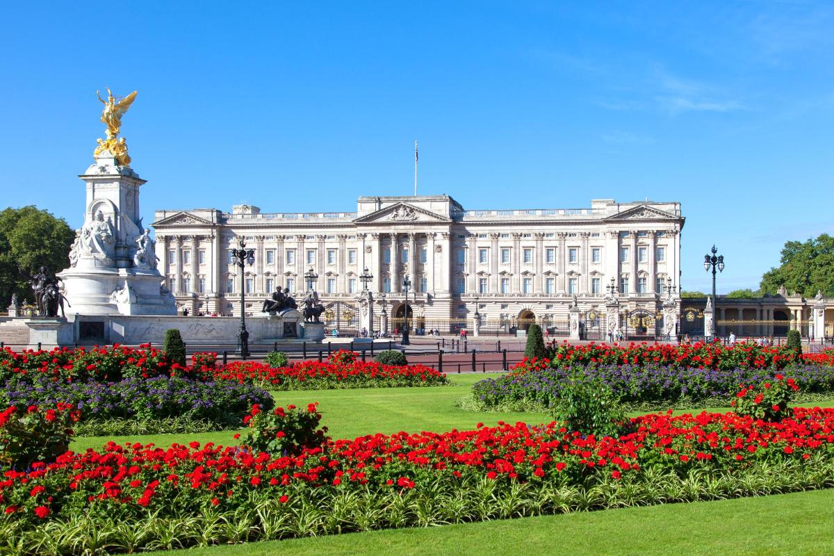 Un gran edificio blanco con flores delante.