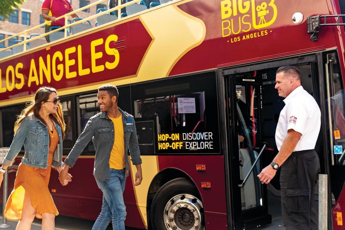 a group of people walking out of a bus