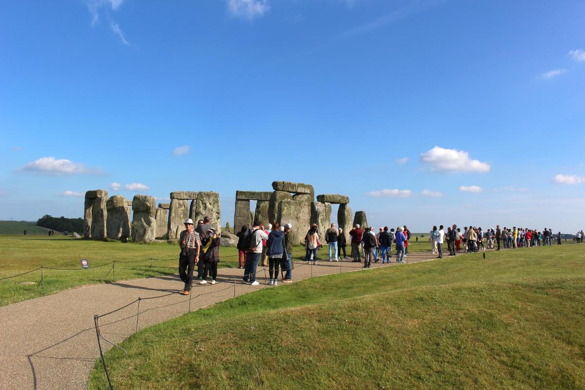 un folto gruppo di persone che camminano intorno a Stonehenge