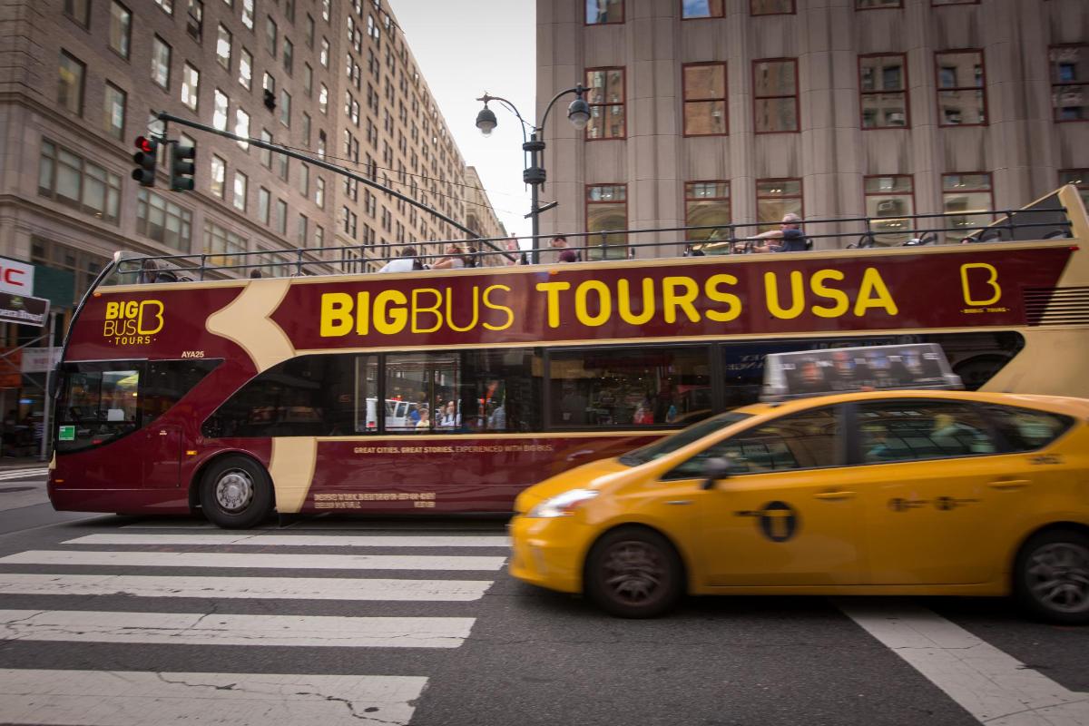 a bus and a yellow taxi in front of a bus