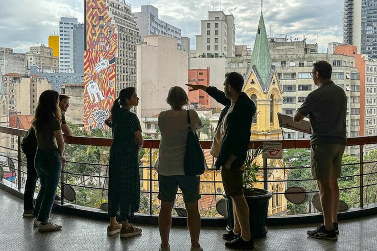 a group of people standing on a balcony looking at a city
