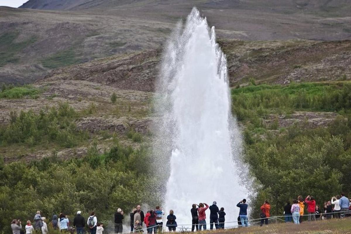 um grupo de pessoas em pé em frente a uma cachoeira