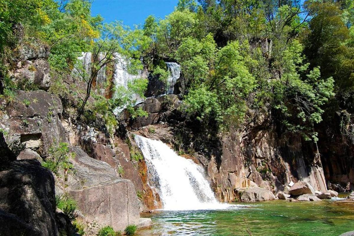 una cascata sul fianco di una montagna rocciosa