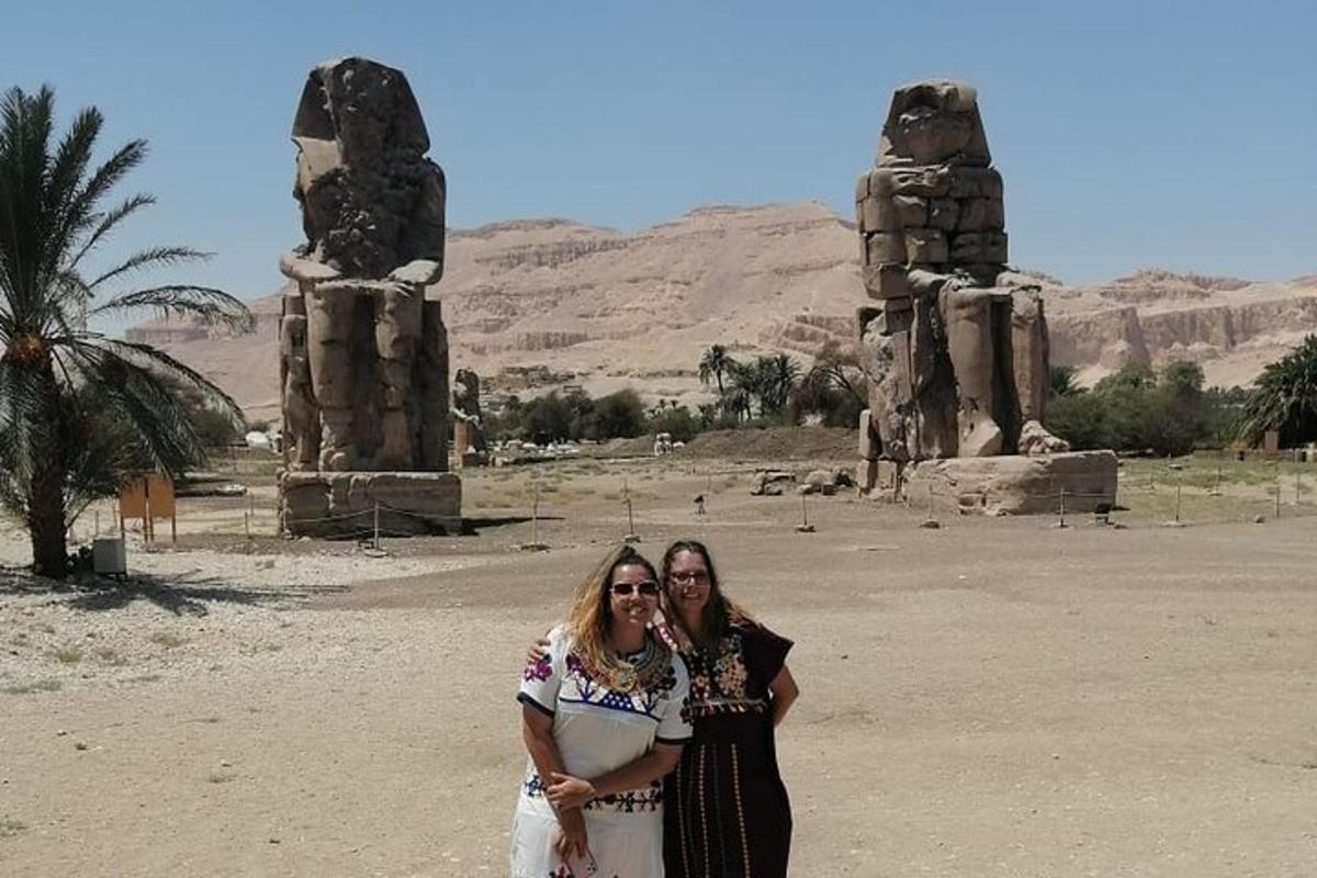 due donne sono in piedi davanti ad alcune statue