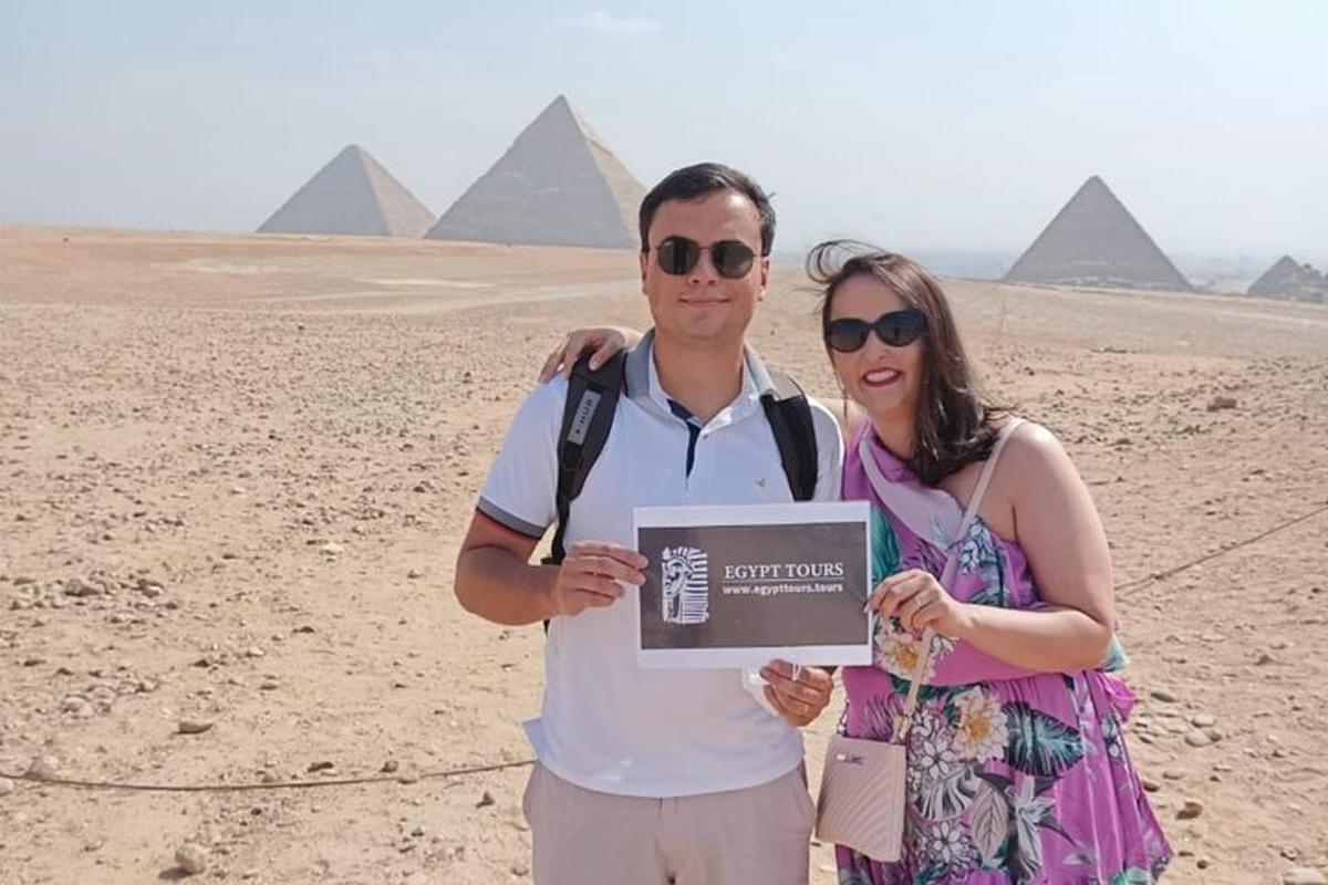 muž a žena stojaci pred pyramídami