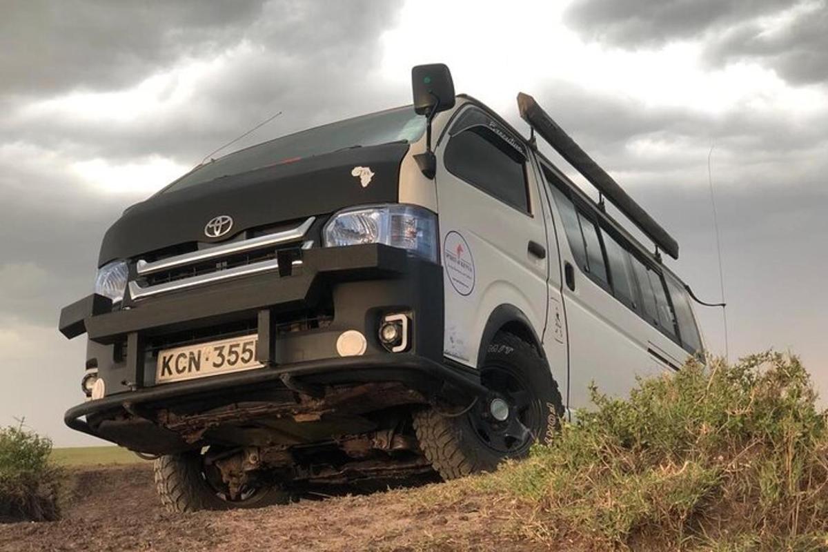 Un autobús blanco y negro estacionado en un camino de tierra