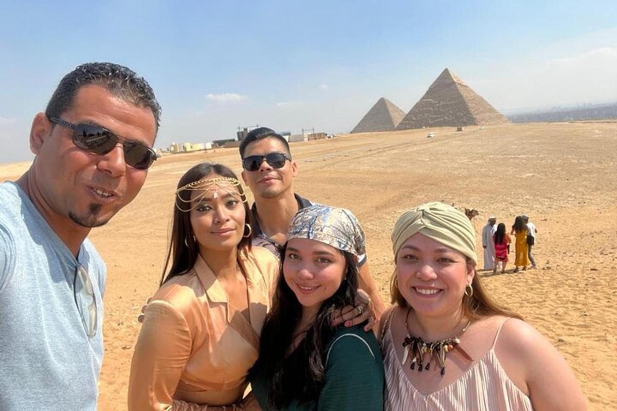 un gruppo di persone in piedi davanti alle piramidi