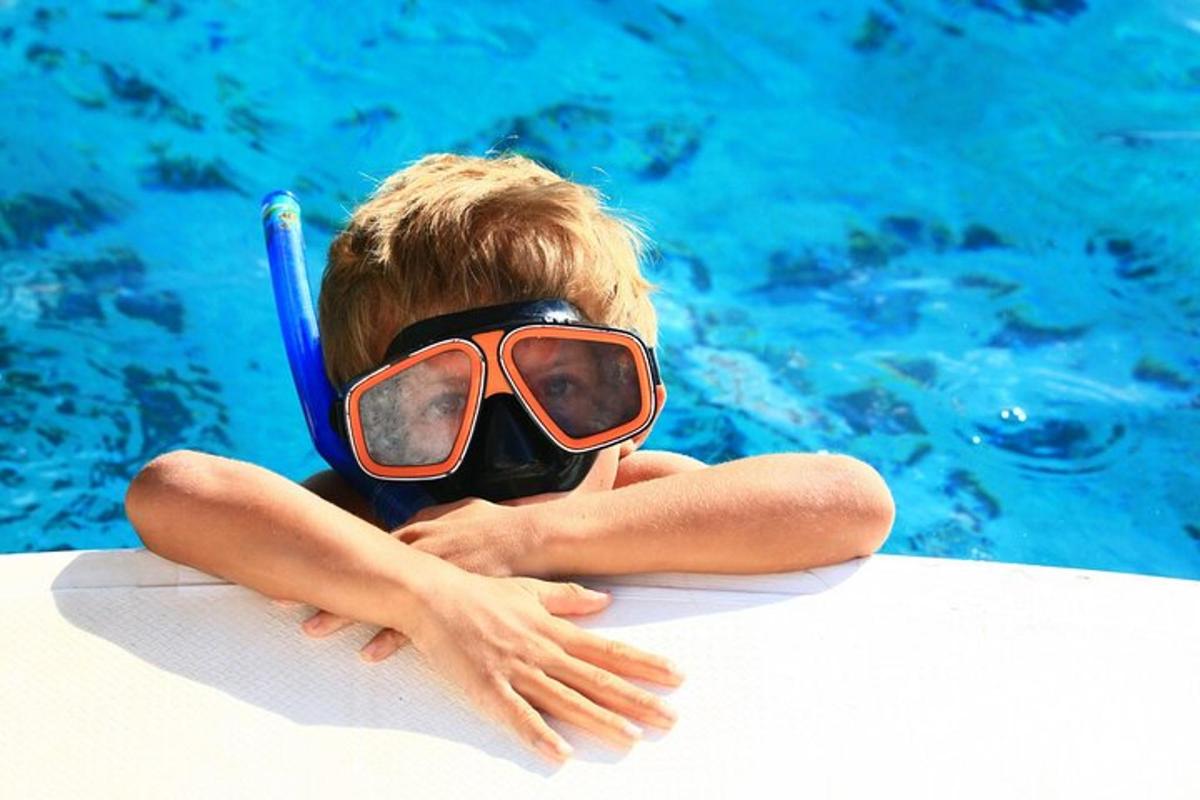 un băiat purtând o mască de scufundări într-o piscină