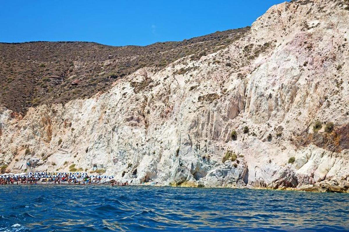 a group of people on the water near a mountain