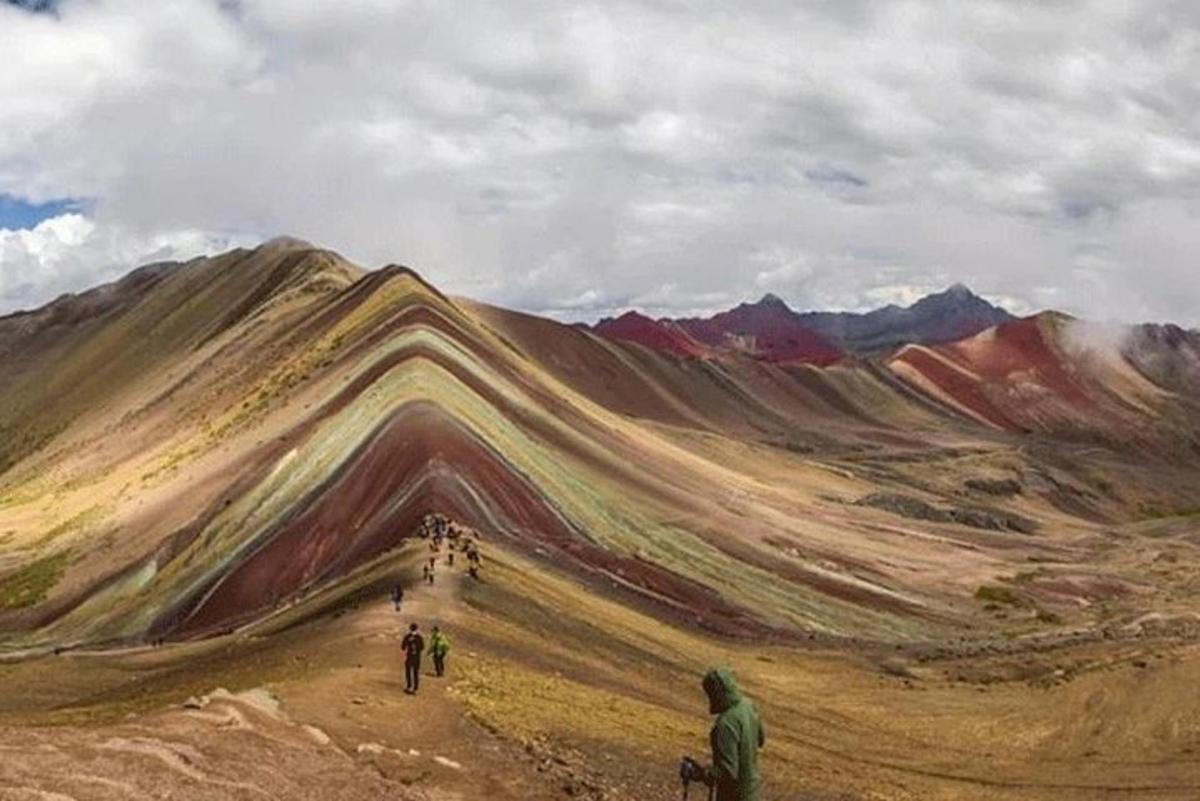 uma pintura de uma montanha com pessoas caminhando em uma estrada de terra