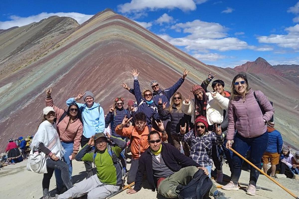 a group of people posing in front of a mountain