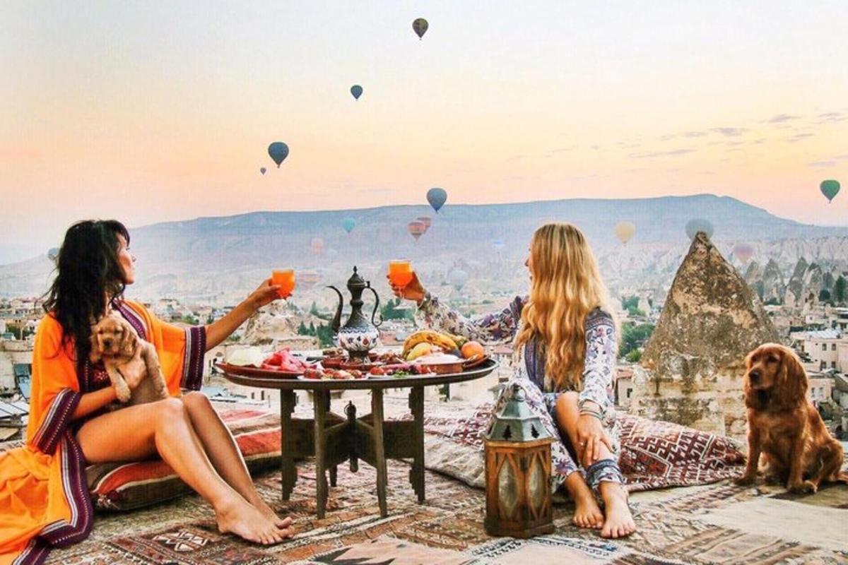 Dos mujeres sentadas en una mesa con comida y globos aerostáticos.