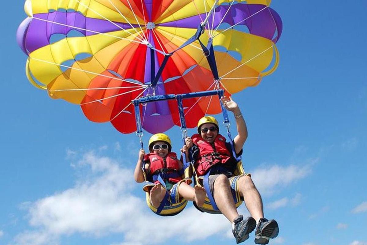 two people are riding on a parachute
