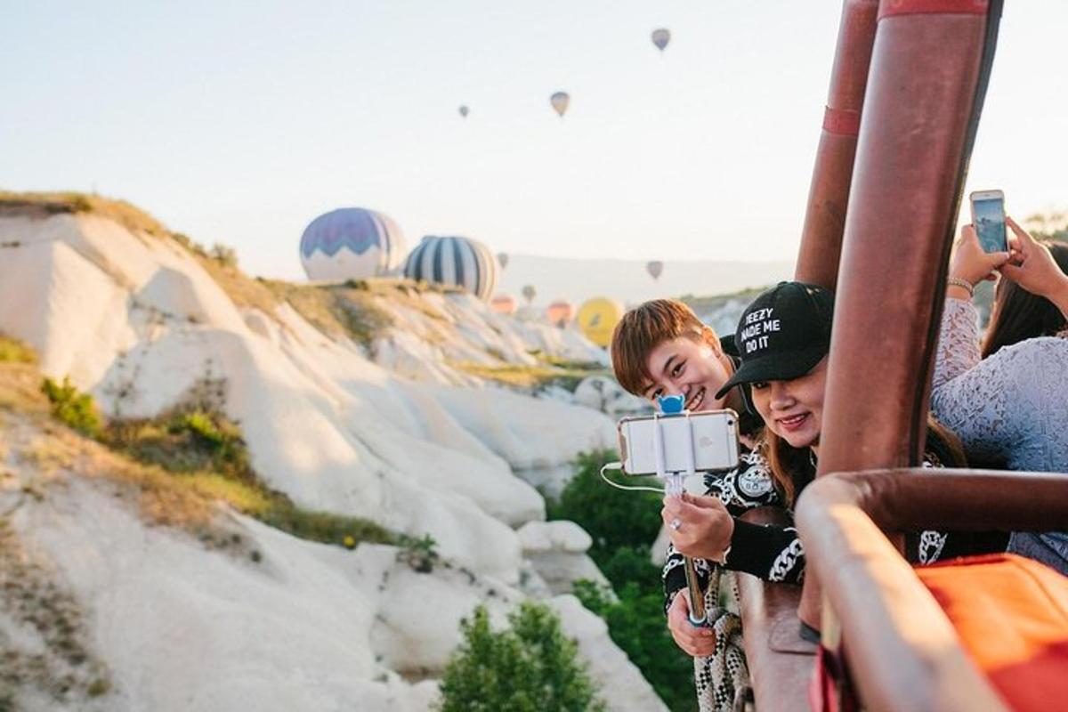 Un grupo de personas tomando fotografías de un globo aerostático.