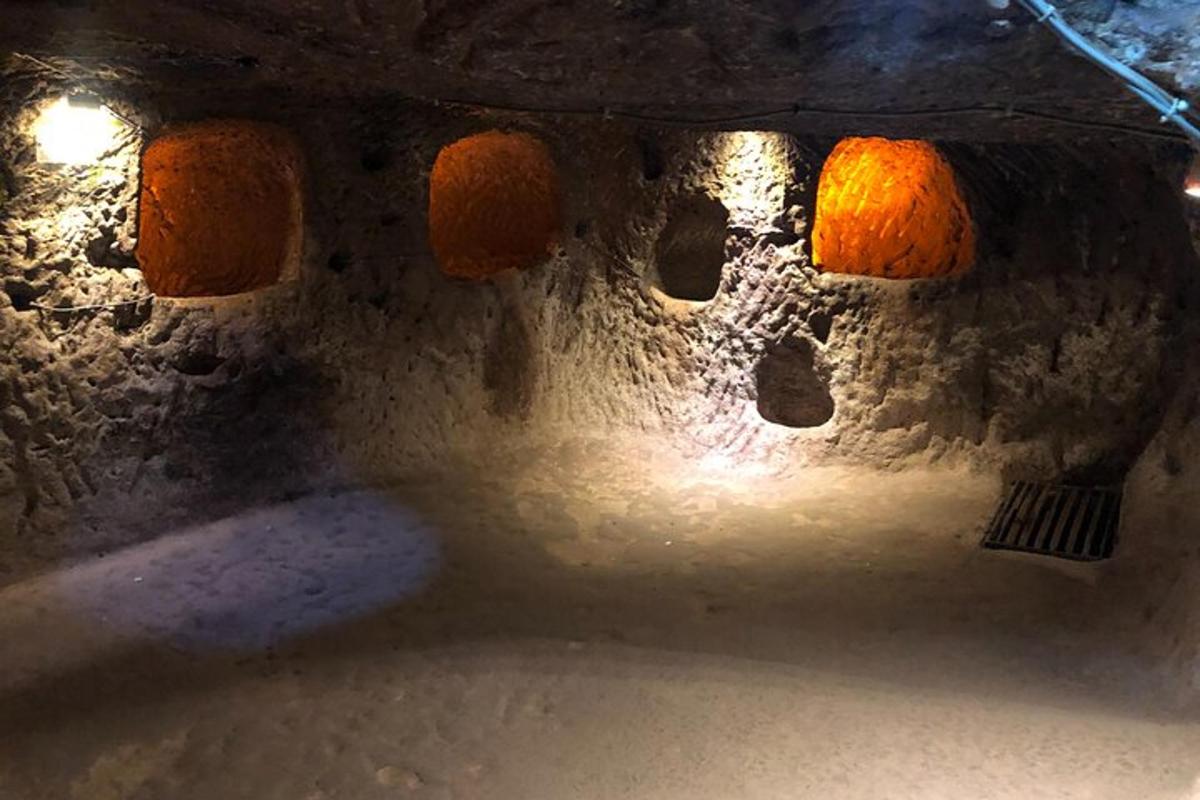 isang madilim na silid na may pader na bato na may mga ilaw