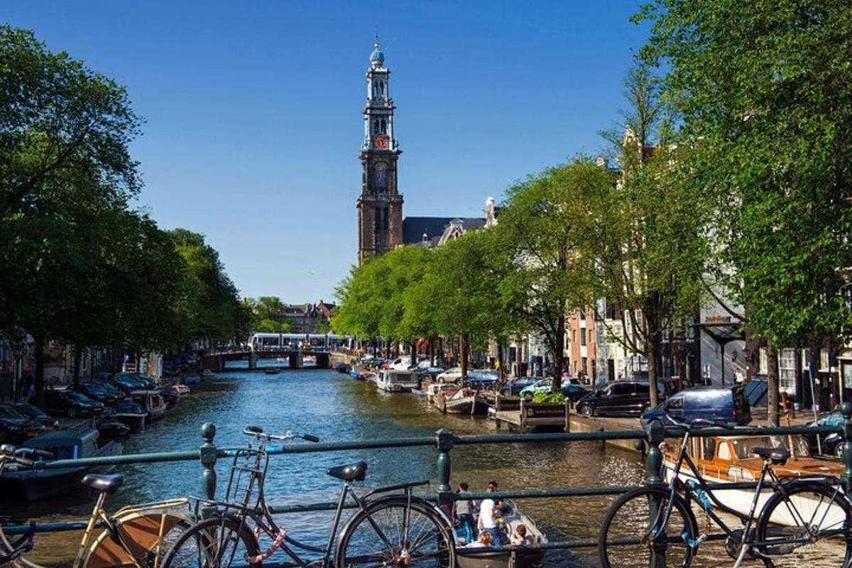 a group of bikes parked next to a river with a clock tower