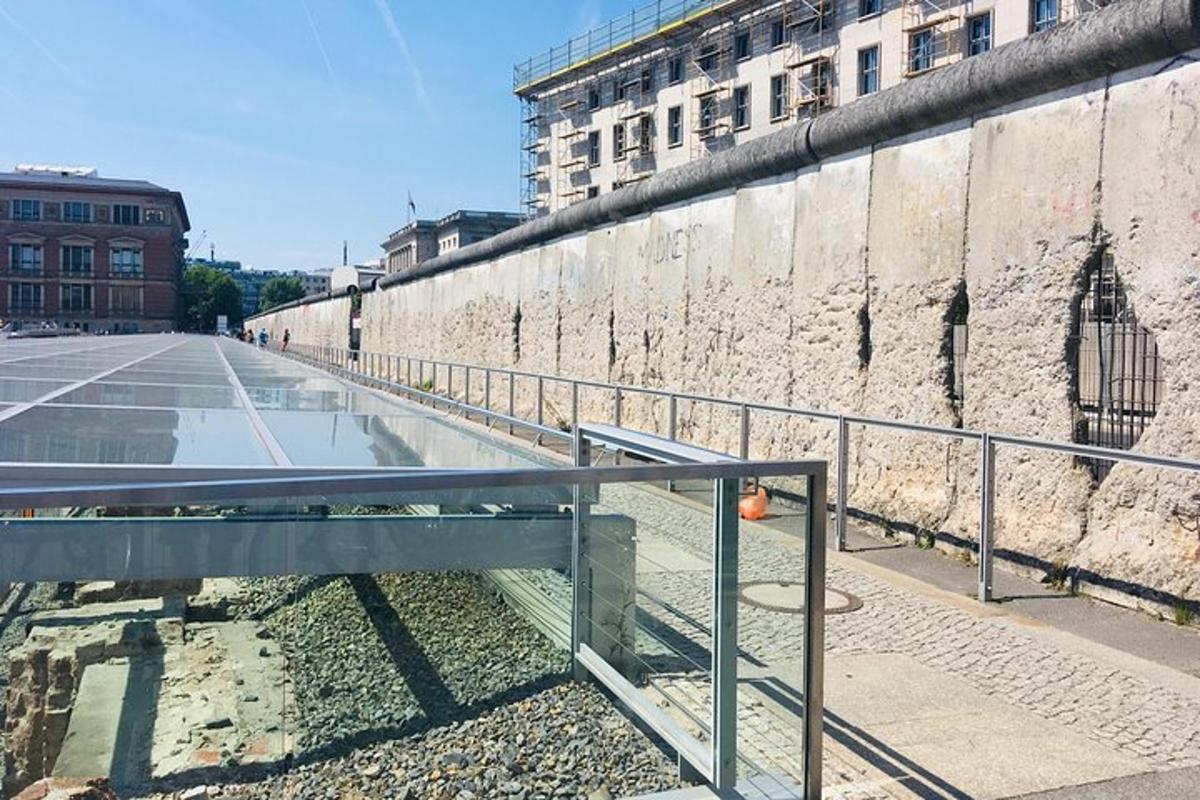 Una calle vacía junto a un gran muro de piedra