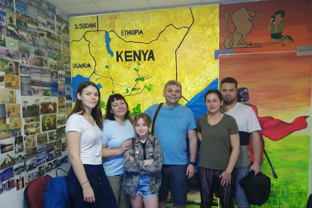 una famiglia posa per una foto davanti a un murale