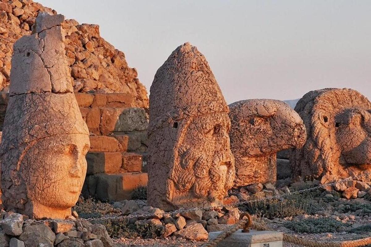 a group of statues of heads in a desert