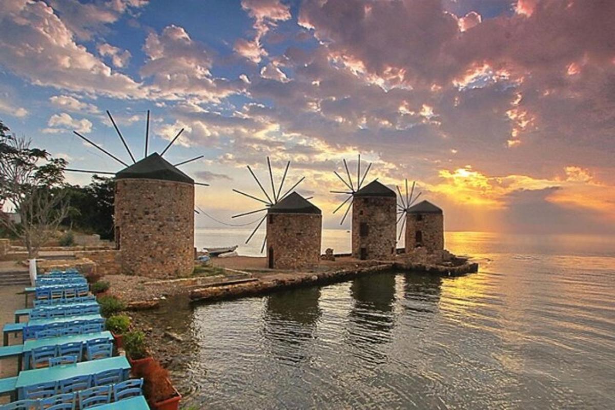 a group of windmills in the water at sunset
