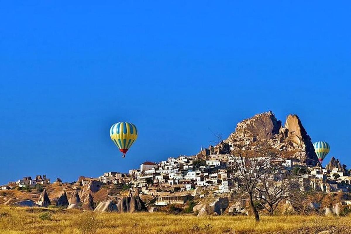 three hot air balloons flying over a mountain
