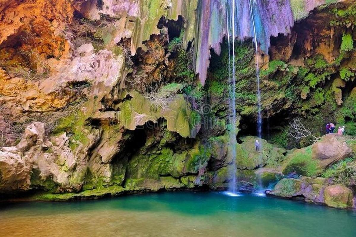 an aerial view of a waterfall in a canyon