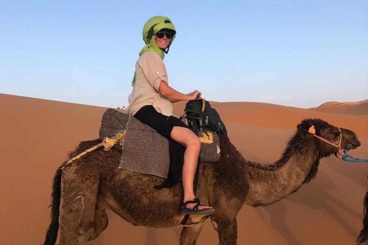 a woman riding on a camel in the desert