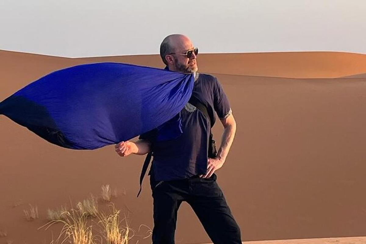 a man walking with a blanket on his back