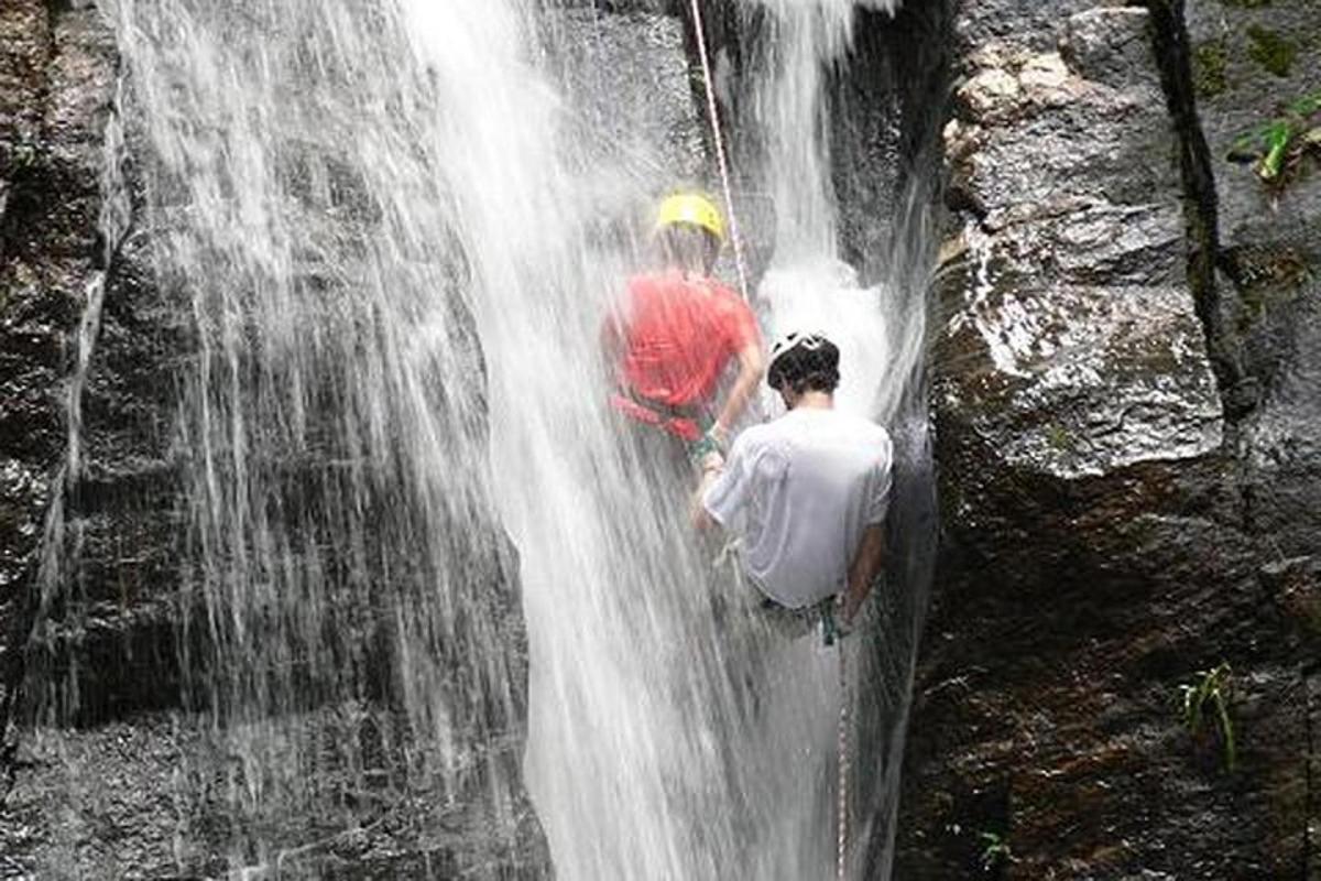 a man standing in front of a waterfall