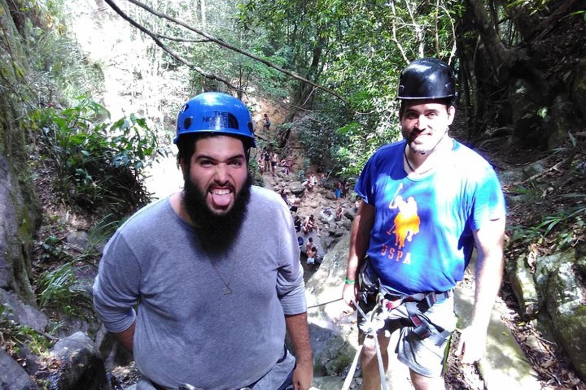 two men wearing helmets standing on a mountain trail