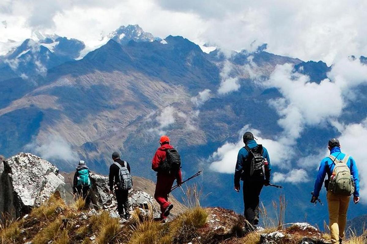 eine Gruppe von Menschen, die auf einem Berggipfel spazieren gehen