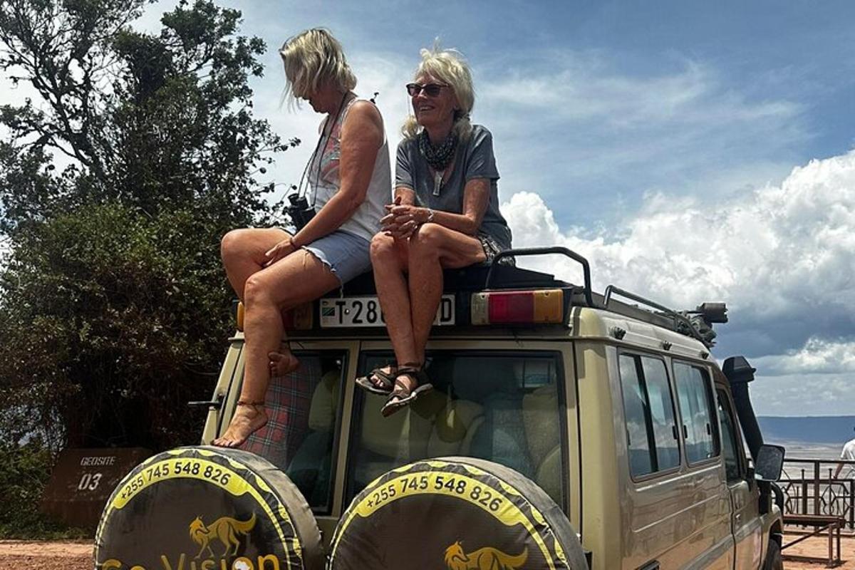 duas mulheres sentadas em cima de um veículo