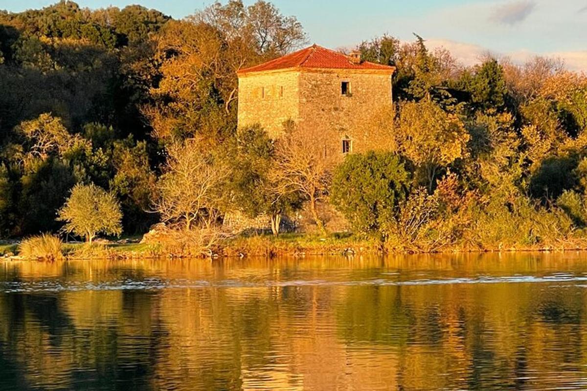 ένα παλιό κτίριο που βρίσκεται στην άκρη ενός υδάτινου σώματος