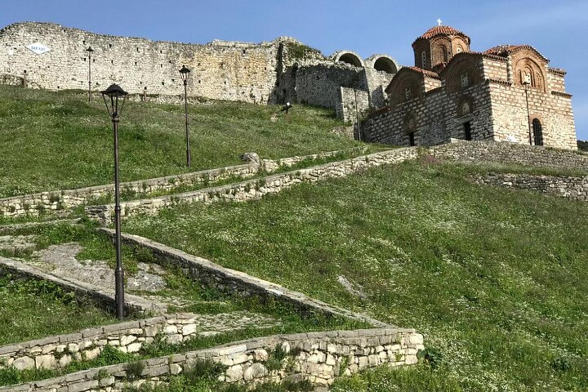 ένα παλιό κτίριο στην κορυφή ενός καταπράσινου λόφου